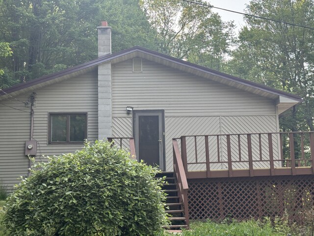 19084 200th Ave, Tustin, MI 49688 - back of property with stairs, a wooden deck, and a chimney