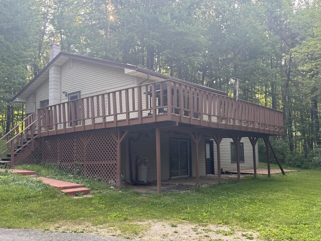 19084 200th Ave, Tustin, MI 49688 - rear view of house featuring a chimney, a wooden deck, and a yard