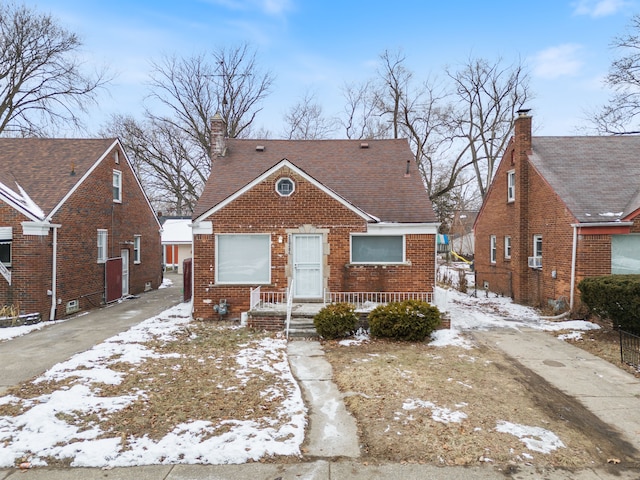 bungalow with brick siding and a chimney