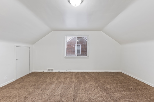 additional living space with lofted ceiling, carpet floors, visible vents, and baseboards