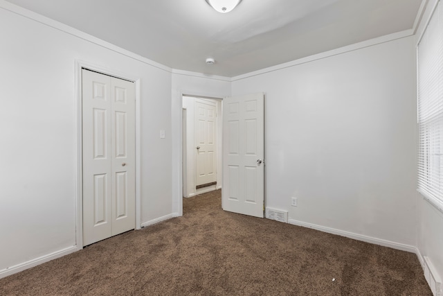 unfurnished bedroom featuring baseboards, a closet, visible vents, and carpet flooring