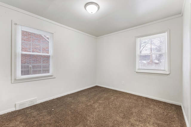 empty room featuring carpet, visible vents, and baseboards