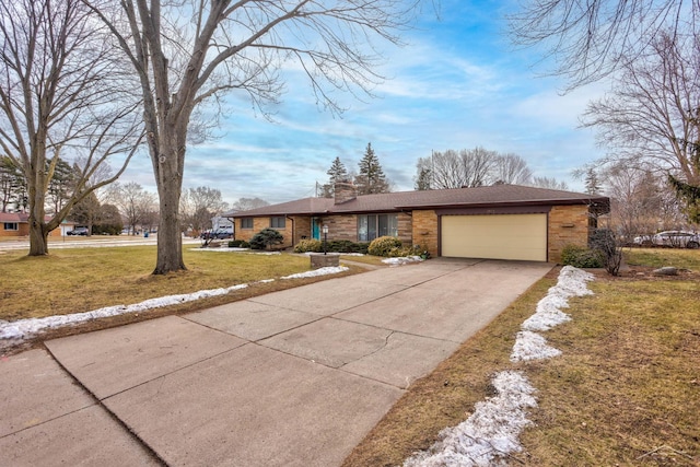 view of front of home with an attached garage, brick siding, driveway, a front lawn, and a chimney