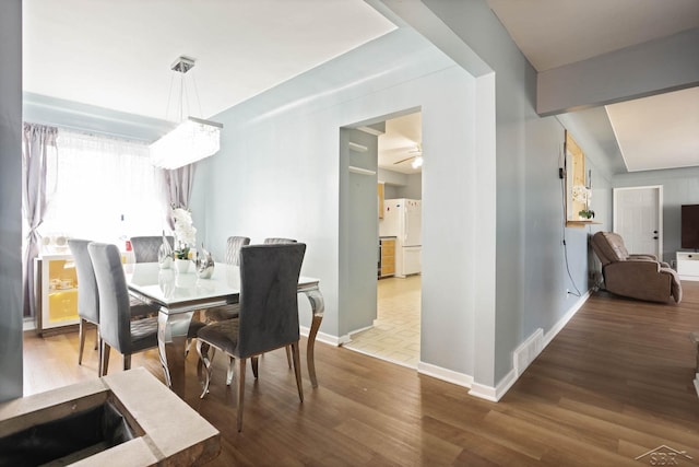 dining room featuring visible vents, ceiling fan, baseboards, and wood finished floors