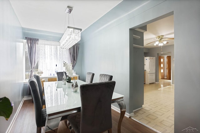 dining area with ceiling fan, baseboards, and wood finished floors