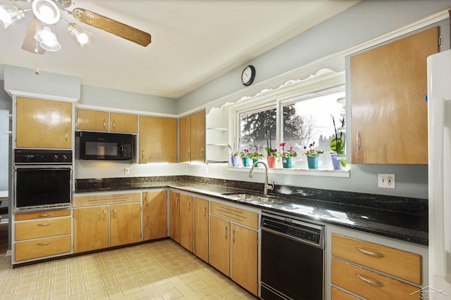 kitchen with ceiling fan, dark stone countertops, light floors, black appliances, and a sink