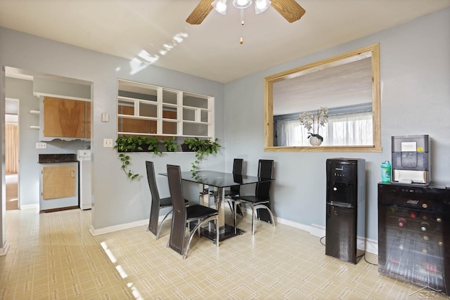 dining room with a ceiling fan, washer / clothes dryer, and baseboards