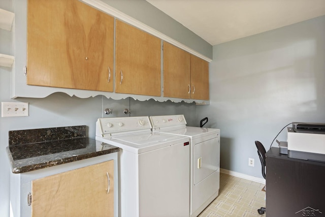 washroom featuring cabinet space, baseboards, and separate washer and dryer