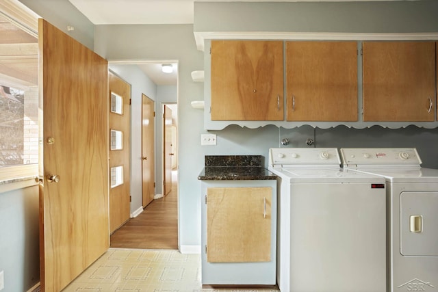 laundry area featuring cabinet space, washing machine and dryer, baseboards, and light floors