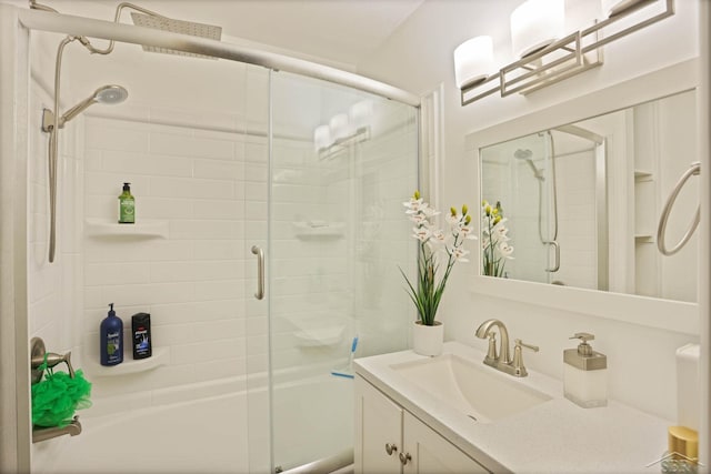 bathroom featuring combined bath / shower with glass door and vanity