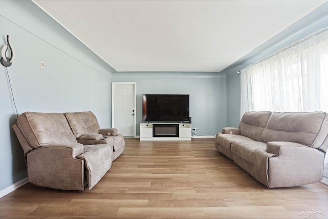 living room featuring light wood-type flooring and baseboards