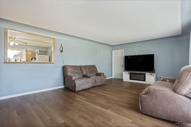 living area featuring baseboards and wood finished floors