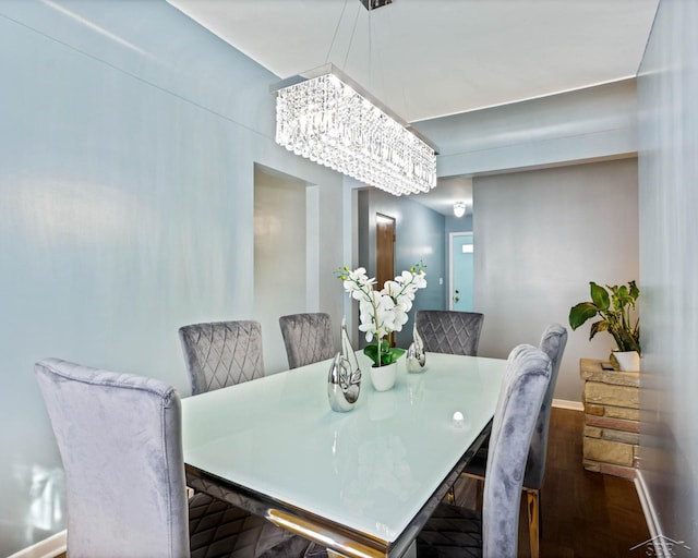 dining room with a chandelier, baseboards, and wood finished floors