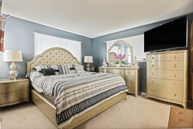 bedroom featuring light carpet and multiple windows