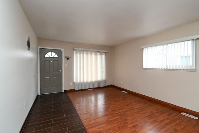 entrance foyer featuring visible vents, baseboards, and wood finished floors