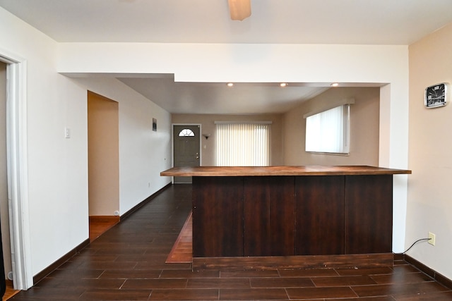 kitchen with dark brown cabinetry, baseboards, wooden counters, and wood tiled floor