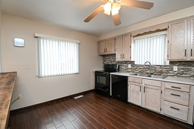 kitchen with backsplash, wood finish floors, light countertops, black appliances, and a sink