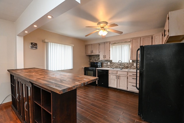 kitchen featuring butcher block countertops, black appliances, a sink, tasteful backsplash, and dark wood finished floors