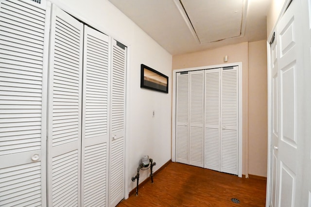 hall featuring baseboards and dark wood-style flooring