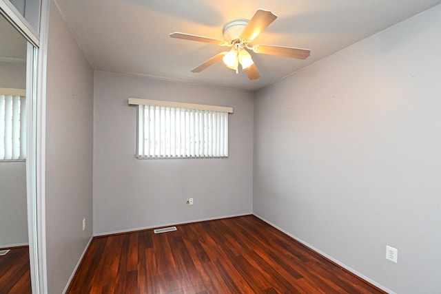 empty room with visible vents, baseboards, a ceiling fan, and wood finished floors