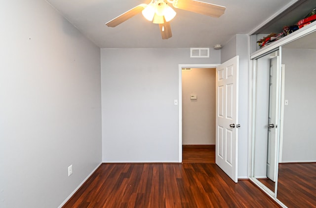 unfurnished bedroom featuring wood finished floors, visible vents, baseboards, ceiling fan, and a closet