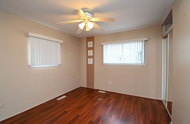 spare room featuring a ceiling fan, wood finished floors, and visible vents