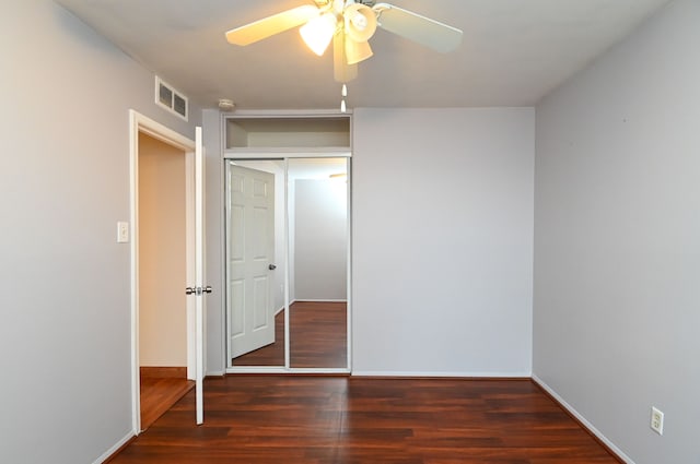 unfurnished bedroom with visible vents, a ceiling fan, wood finished floors, a closet, and baseboards