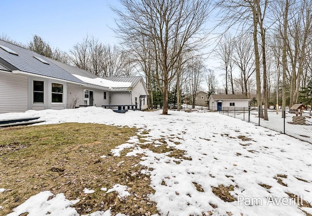 yard layered in snow with fence and an outdoor structure