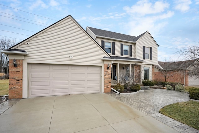 traditional home with a shingled roof, concrete driveway, brick siding, and an attached garage