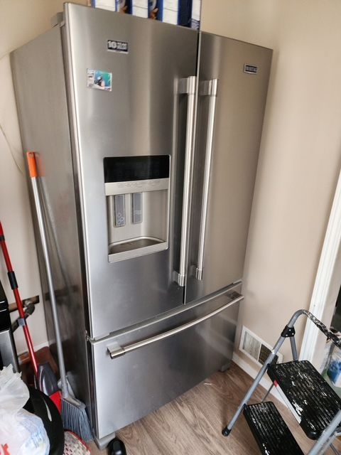 interior details featuring visible vents, stainless steel refrigerator with ice dispenser, and wood finished floors