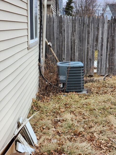 exterior details featuring central AC unit and fence