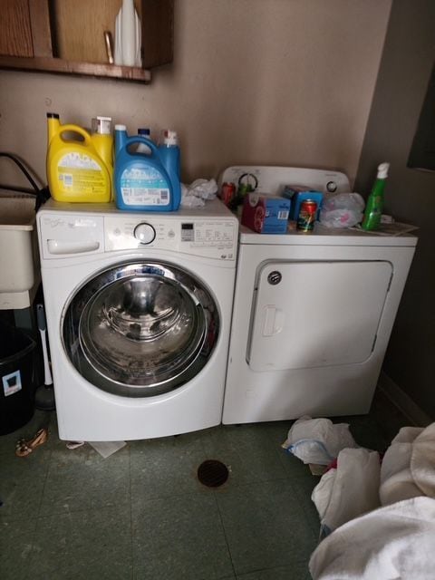 laundry room featuring separate washer and dryer and cabinet space