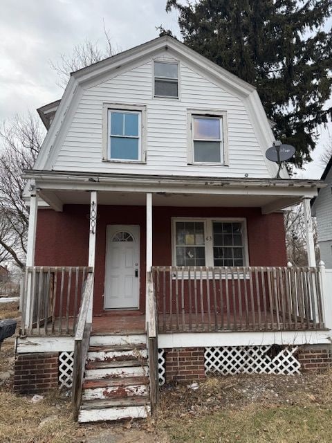 dutch colonial with a porch and a gambrel roof