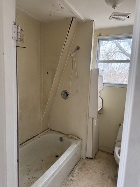 full bath with toilet, visible vents, and tub / shower combination