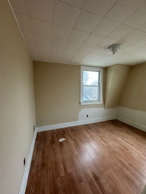 bonus room featuring wood finished floors and baseboards