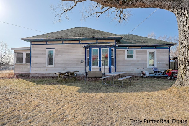 rear view of property with a yard