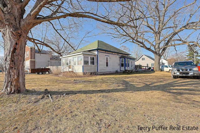 view of home's exterior featuring a yard and a sunroom