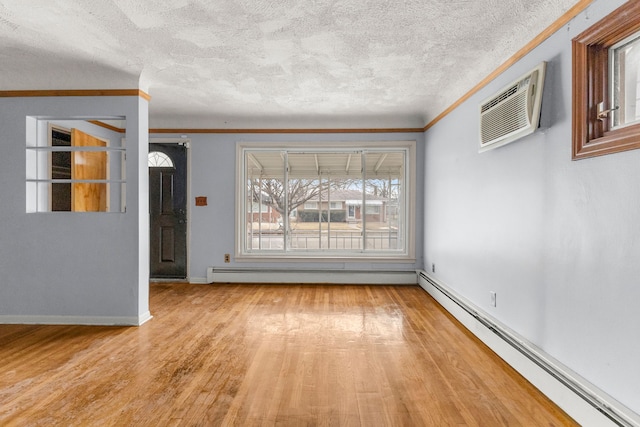 unfurnished room featuring a wall unit AC, crown molding, light wood finished floors, and baseboard heating