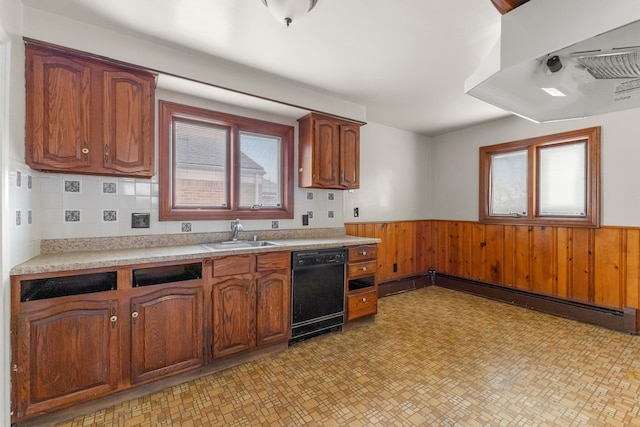 kitchen featuring a baseboard radiator, light countertops, wainscoting, a sink, and dishwasher