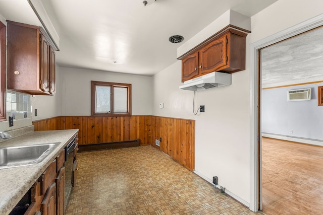 kitchen featuring wainscoting, baseboard heating, a sink, and a wall mounted AC