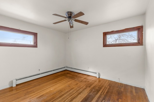 spare room with wood-type flooring, ceiling fan, and baseboard heating