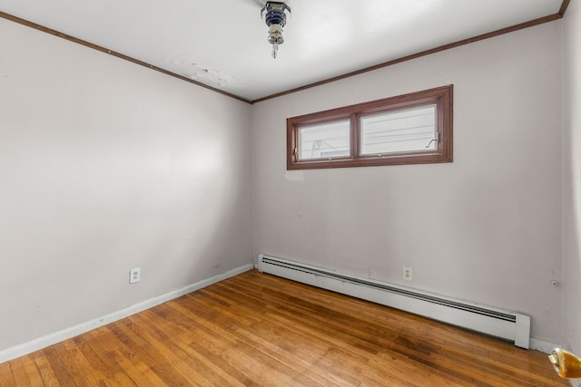 spare room with light wood-style flooring, ornamental molding, baseboard heating, and baseboards