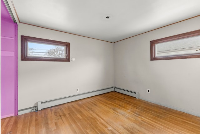 spare room featuring light wood finished floors and a baseboard radiator