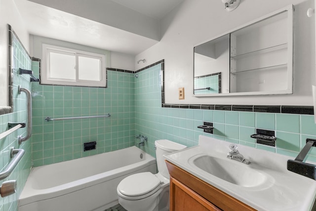 bathroom with wainscoting, toilet,  shower combination, vanity, and tile walls