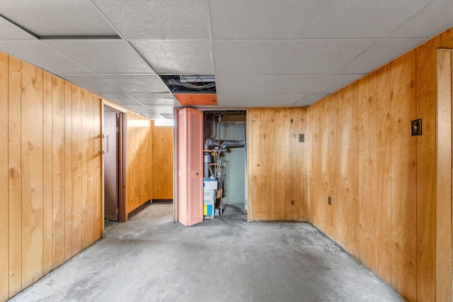 finished below grade area featuring wood walls and a paneled ceiling