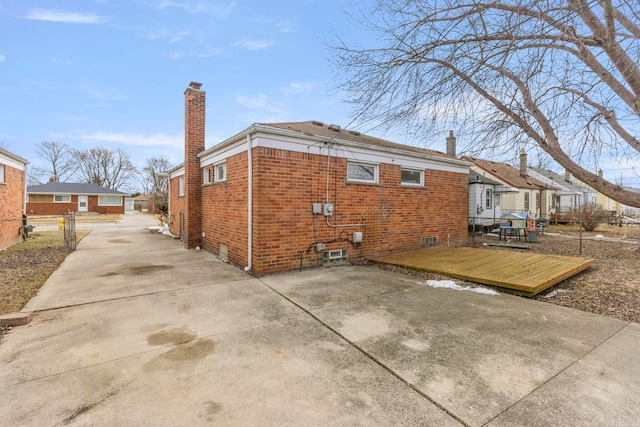 back of property featuring a chimney, fence, a patio, and brick siding