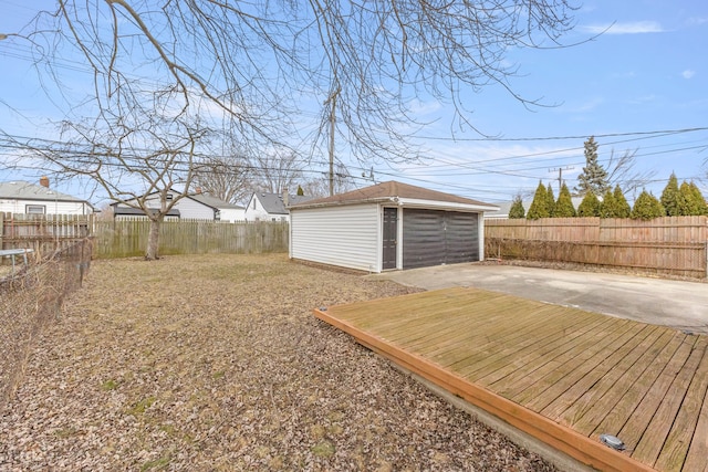 view of yard featuring a fenced backyard, an outdoor structure, a detached garage, and a patio