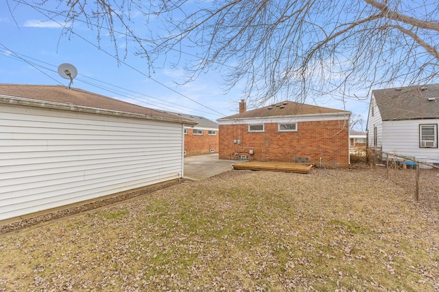 back of property with a chimney, an outbuilding, crawl space, fence, and brick siding