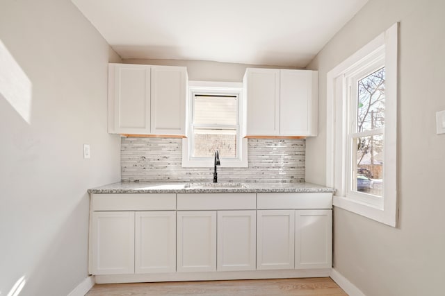 kitchen featuring a wealth of natural light, tasteful backsplash, and a sink