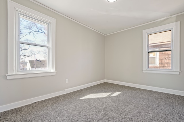 empty room featuring carpet floors, ornamental molding, and baseboards